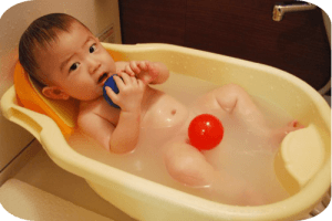 Bebé bañandose con pelota azul y roja